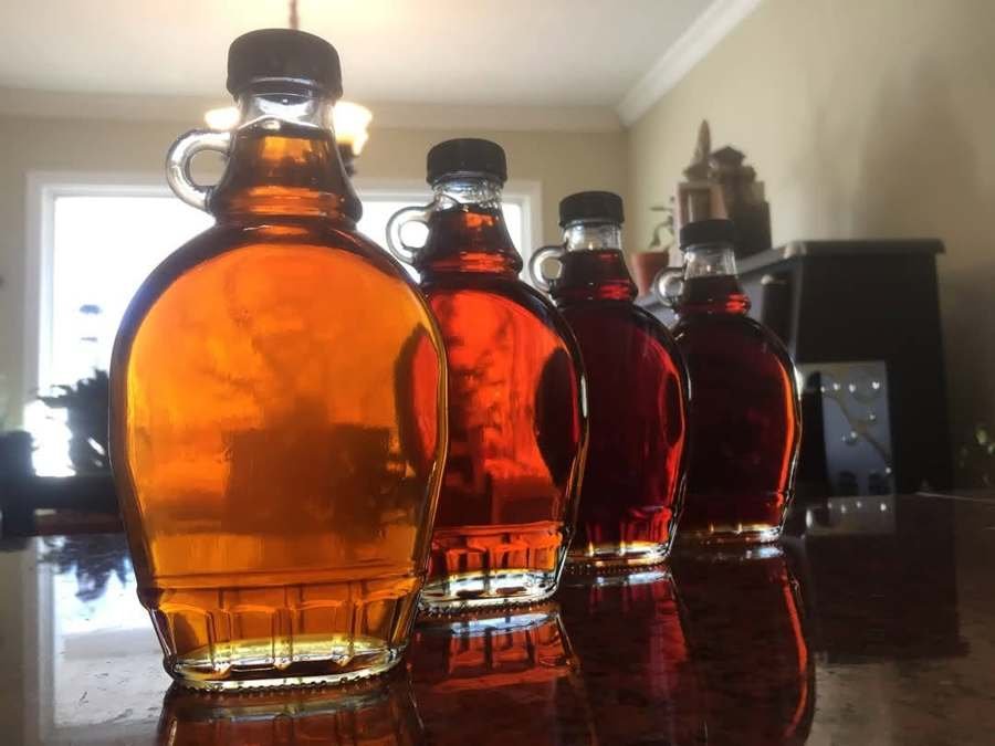 Quatre bouteilles de sirop d'érable, du doré au très foncé